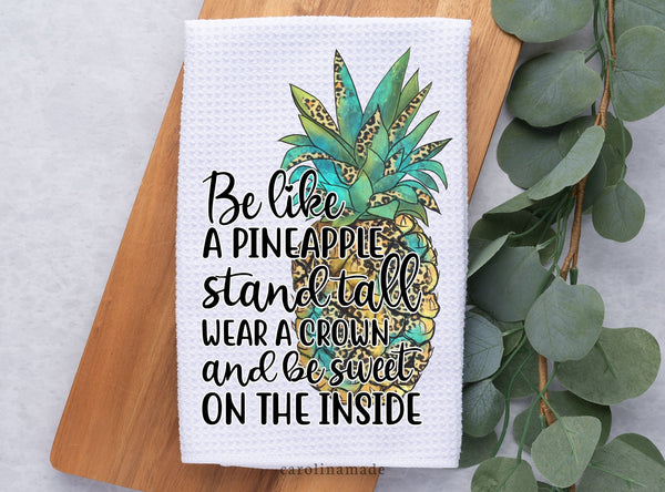 Be like a pineapple stand tall wear a crown and be sweet on the inside quote with leopard print pineapple in the background on a white waffle weave towel