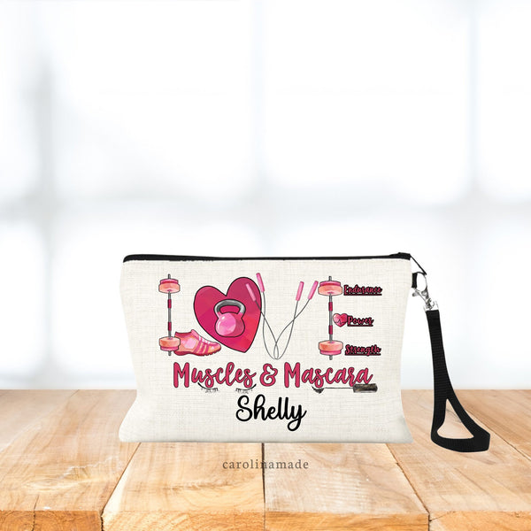 The bag says Muscles and mascara and features the word love above it that is spelled out in gym equipment. Bar bell, kettle bell, jump rope. Perfect for weight lifters! Personalized with name on the bottom under design.