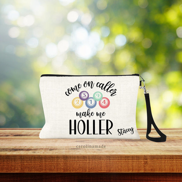 Linen wristlet is natural fiber color and has bingo ball design that says Come on caller make me HOLLER. Personalized with your name in the corner.