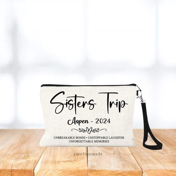 Personalized Linen wristlet that says Sister Trip big across the top. Under it says the location and date. at the bottom the text says Unbreakable bonds, unstoppable laughter, unforgettable memories.