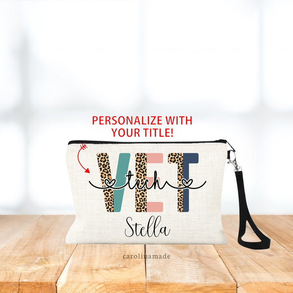 Linen wristlet / make up bag with black strap. Center of bag says VET in large half color half leopard print font. Across the text it has your title. Tech, Receptionist, Assistant, etc.  The bottom is personalized with your name