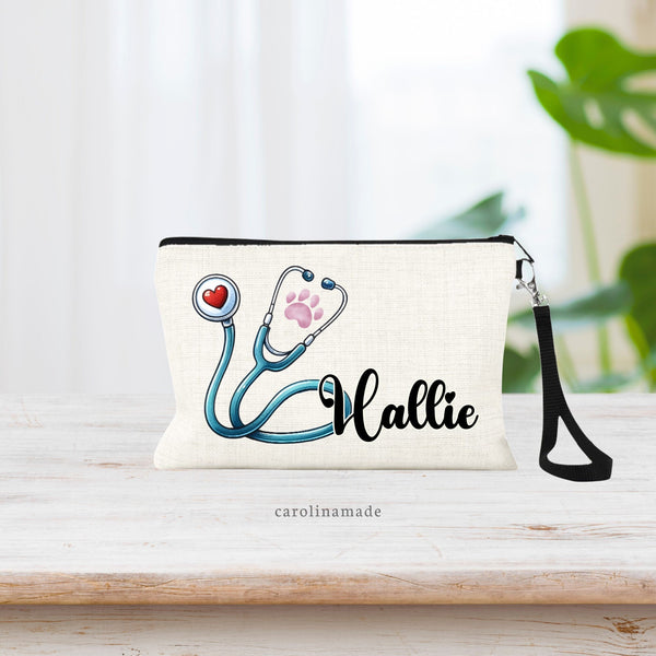 Linen wristlet bag that features a blue green stethoscope with a paw print in the design. Personalized with your name.