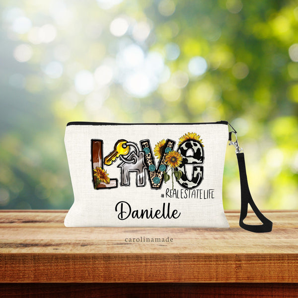 Linen wristlet bag with black strap included. The word LOVE in western cow hide and teal buttons. The O is a house & key. Real Estate Life is under the word LOVE. And under that it is personalized with your name.
