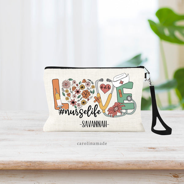 This linen wristlet features the word LOVE big across the bag. The L has a needle on it. The O is flowers in the shape of a heart. The V is a stethoscope. And the E has a bandage and nurse hat on it. Under it says hast tag nurse life w/ your name.