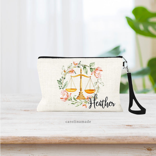 Watercolor Gold scales of justice are in the center of this bag with a watercolor greenery wreath surrounding it that has pops of pink flowers. A name is personalized on this bag on the bottom corner of the wreath.