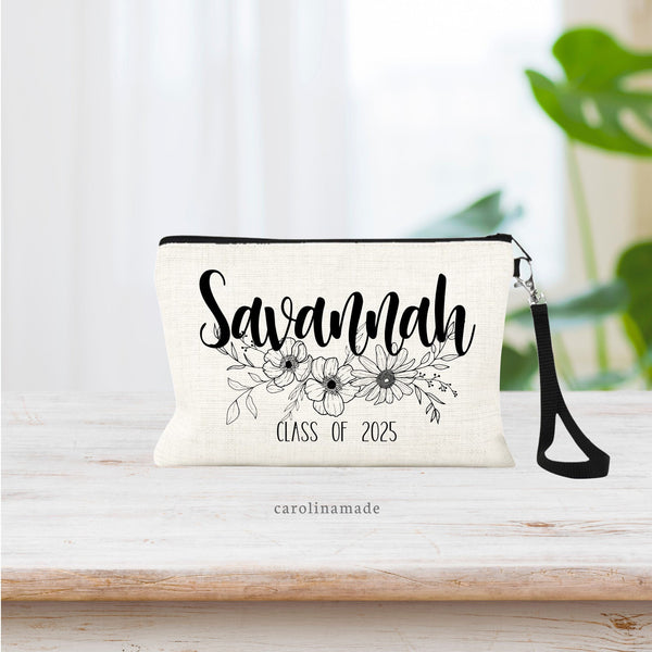 This linen wristlet bag with strap features your name at the top with beautiful line art flowers and leaves. The bottom says CLASS OF 2025. Can be customized to say whatever year you need!