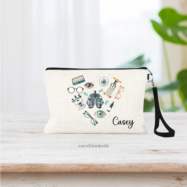 This linen wristlit is perfect for ophthalmic technician or doctor. It features a name personalized in bottom corner. The main design is ophthalmology items in the shape of a heart. Eye glasses, contacts, eyeballs, drops, testing equipment, chart.