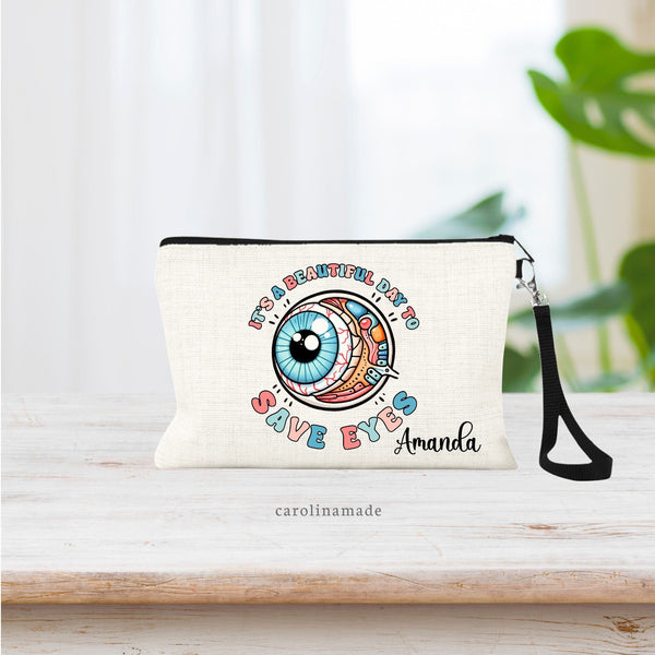 This linen wristlet for Ophthalmologist feature a large eye ball in the center of the bag with the text around it that says it's a beautiful day to save eyes. A name is personalized in bottom right corner.