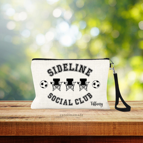 This linen wristlet is the perfect game day accessory! It says Side Line Social Club and features 3 foldout camping sports chairs and two soccer balls on the side. Personalized with a name on the bottom right corner for your Soccer Mom Friends