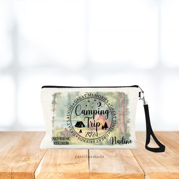 This linen zipper pouch features a circle that says: Camping Trip, with stars, moon, trees, tent and fire. The year is noted. Personalize with your name and destination. Background shows woods, tent & lake campsite setting.