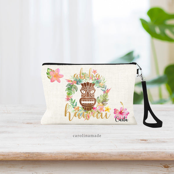 This linen zipper pouch features a Hawaiian lae in the background with a tiki over it. It says aloha Hawaii with your name personalized in the corner. There are beautiful watercolor Hawaiian flowers and greenery.