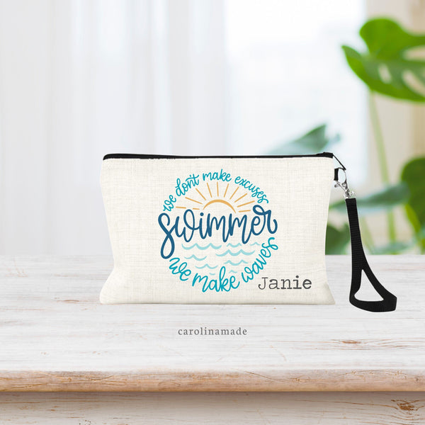 This linen wristlet with strap features the text: we don't make excuses, we make waves. withthe word Swimmer in the center and a sun and water waves. Personalize with a name in the bottom right corner.