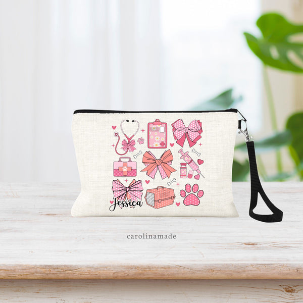 This linen wristlet features a preppy trendy pink bow coquette design featuring bows and veterinary items. Stethoscope, need, animal carrier, paw print, and vet bag. Personalize with your name on the bottom left bow.