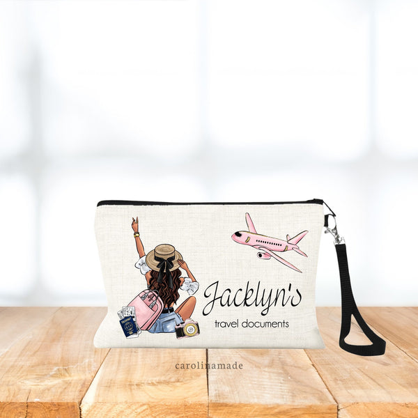 Travel documents zippered pouch features a customizable girl sitting with a bag, passport, airline tickets and camera. The text next to it says (name)'s travel documents. Hair & Skin tone is customizable.