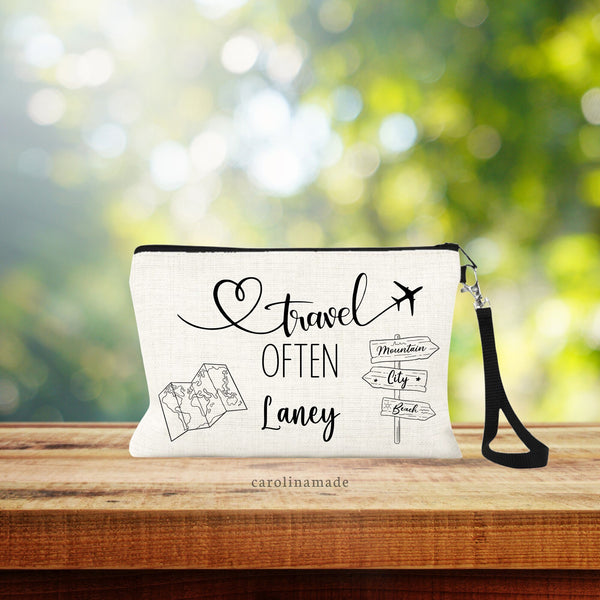 This natural linen bag features the text travel often with line art of a wooden sign with arrows pointing to mountain, city & beach.  The other side has a paper map of the world. And a personalized name is centered at the bottom.