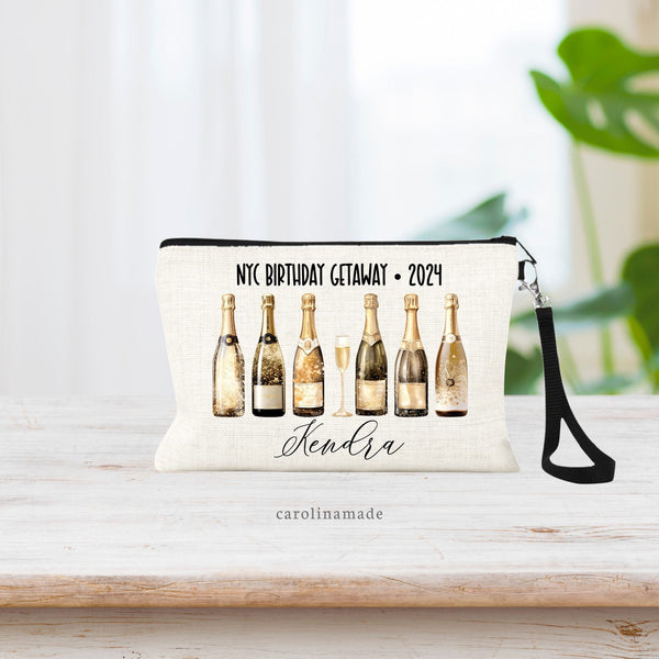 This linen zipper pouch features classy gold champagne bottles in a row. Text at the top can be customized your trip and the name is personalized at the bottom.