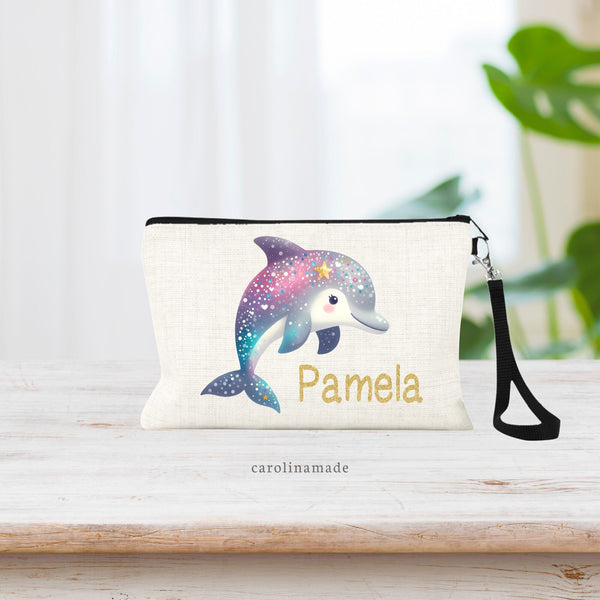This zipper pouch shoes a large blue, teal and pink dolphin with a gold star fish on her head. The bag is personalized in printed gold glitter font on bottom right corner.