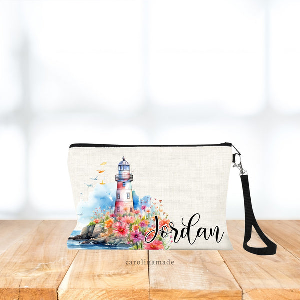 This linen wristlet features a watercolor style lighthouse design with lighthouse on cliff with ocean and flowers. Personalize this bag with your name on the bottom right corner.