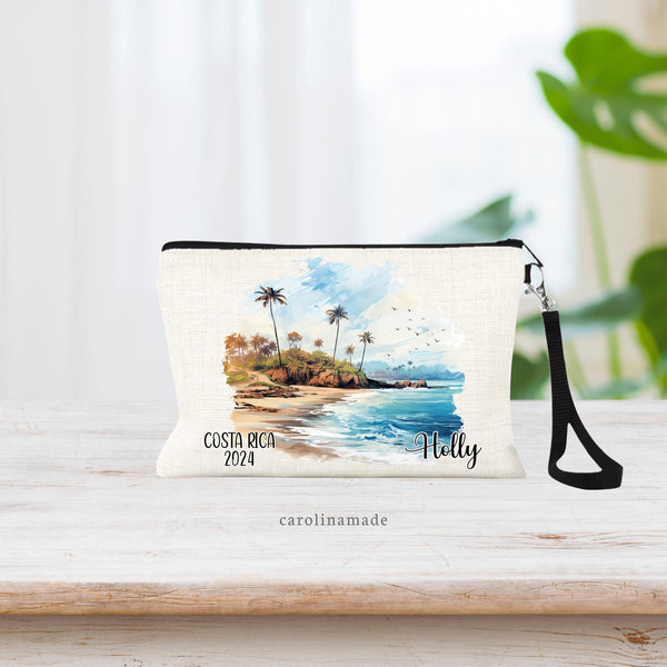 Watercolor Costa Rica Beach Scene with palm trees in the center of the wristlet. The bottom says Costa Rica and the current year on the left. The right is personalized with your name.