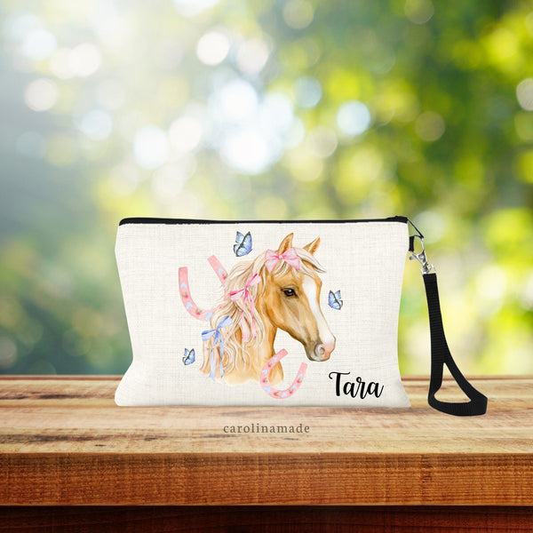This linen zipper pouch features a beautiful horse with pink and blue coquette bows, pink horse shoes and blue butterflies. It is personalized at the bottom with your name.