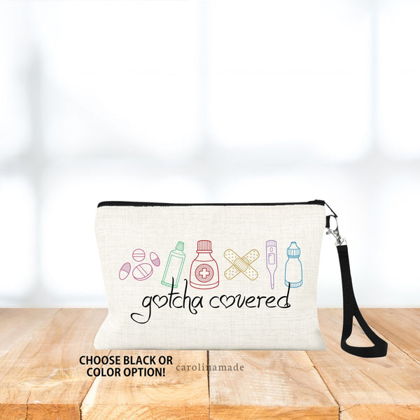 This linen wristlet is the perfect accessory to hold your first aid stuff. The design on the bag shows minimalist line art of medicine, ointment, band aids, thermometer and eye drops.  Under it says Gotcha Covered. Choose black or color option