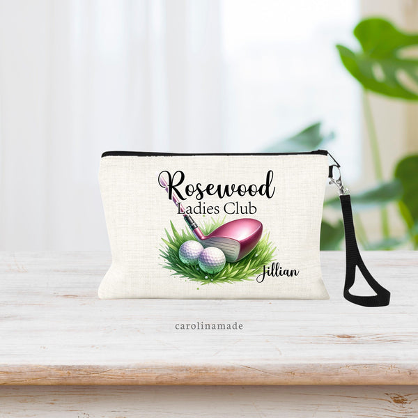 Womens golf zipper pouch featuring pink golf club with two balls and grass surrounding it. The top of the bag has your Country Clubs name and the bottom is personalized with your name in the corner.