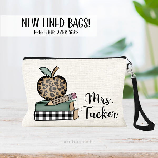The perfect teacher appreciation gift! A stack of school books, leopard print apple & pencil is on the right. The teachers name is personalized next to the books on the right of the zipper pouch.