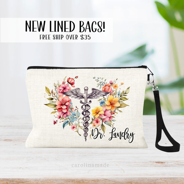 Floral caduceus medical symbol personalized with name in the corner on a linen wristlet with black strap.