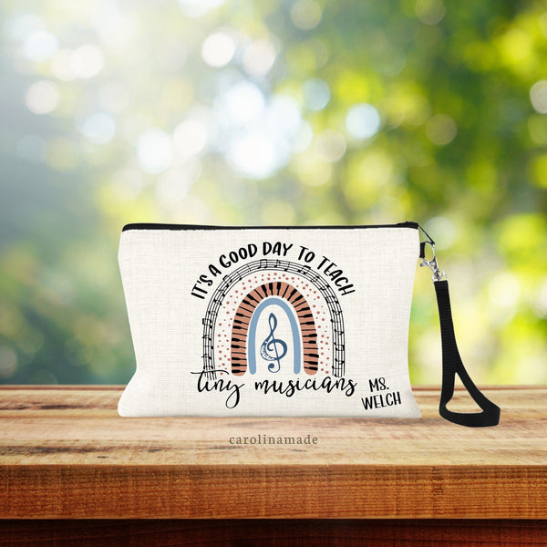 This linen wristlet says It's a good day to teach tiny musicians and it has an awesome musical rainbow filled with music notes, and keyboard keys! The bottom corner is personalized with your music teachers name.