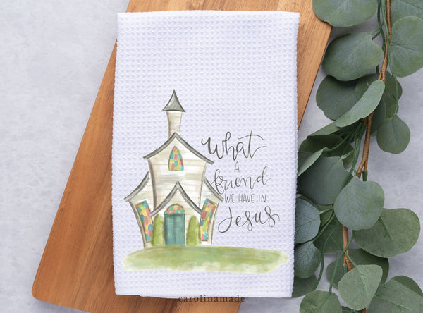 White waffle weave towel featuring beautiful watercolor church and script text that says what a friend we have in Jesus! This hand towel can work great in your kitchen or bathroom.