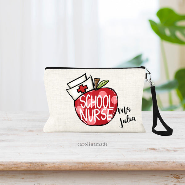 Personalized linen zipper pouch with wristlet for your favorite school nurse! There is a large red apple in the center with faded pokadots, a nurse cap and the apple says SCHOOL NURSE. It is personalized in the bottom corner with their name.