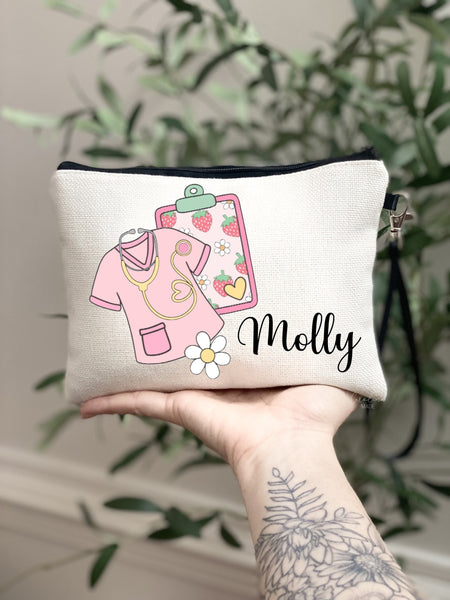 This linen zipper pouch is the perfect gift for any nurse! It features fun trendy pink and strawberry art of a tumbler, scrubs, daisy and clipboard. Personalize with your name at the bottom.
