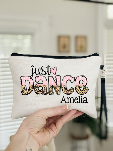 This pouch says Just Dance fun pink font with half leopard print. It is personalized with a name at the bottom.