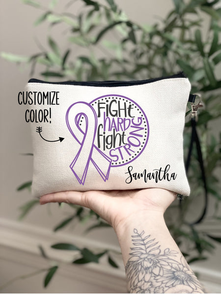 This linen wristlet features a large cancer ribbon in your choice of color with the text fight hard fight strong. It is personalized in the bottom corner with your name.