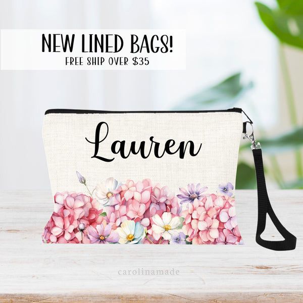 This zipper pouch features pink hydrangea flowers along the bottom border and is personalized at the top with your name.