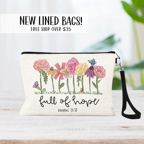 This linen zipper pouch with lining and wristlet has a beautiful floral design with colorful flowers. And says at the bottom: full of hope romans 15:13