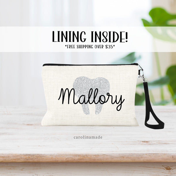 This linen pouch with strap features your choice of printed glitter tooth and is personalized with a name over top.
