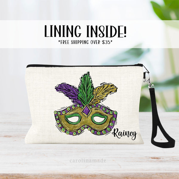 This linen zipper pouch is the perfect accessory for your trip to Mardi Gras! It features a mardi gras mask in purple green and gold. It is personalized with your name in the right corner.