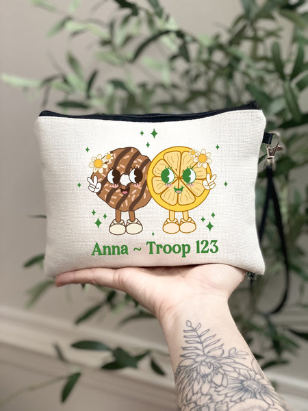 This fun linen bag features two large cookies holding a peace sign and has a smiley face. With the bottom personalized with your girls scouts name and troop number. perfect for cookie selling money collection.