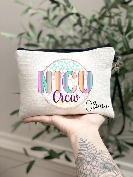 This linen lined makeup bag features a colorful design in the center with text that says NICU Crew. It is personalized in the bottom corner with a name.