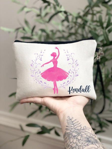 This linen zipper pouch features a beautiful watercolor pink ballerina in the center with a purple watercolor wreath around it. Personalized in the corner with a name.