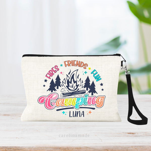 This personalized linen zipper pouch features the text Fires, friends, fun at the top with trees and a campfire. The bottom says Camping in a colorful script and your name is under it.