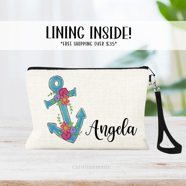 This lined linen zipper pouch wristlet features a beautiful blue anchor with gold outline and is layered with beautiful flowers on top. Personalize the bag with your name next to it.