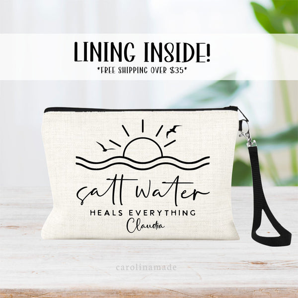 Linen zipper pouch says salt water heals everything. With a minimalist line art design of waves, sun and birds. It is personalized at the bottom with a name.