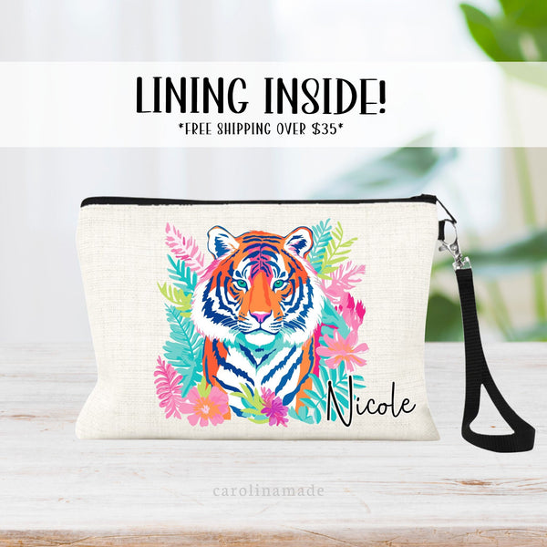 This linen zipper pouch features a pretty tropical floral, palm leaves and greenery design with a tiger in the center. It is personalized in the corner with your name.