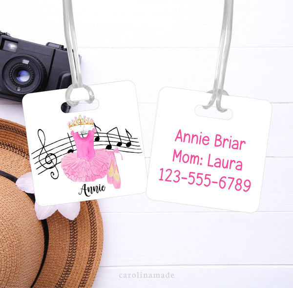 This Bag ID Tag features a pink tutu, crown, ballet slippers and musical design. The front is personalized with a name. The back has Moms contact information.