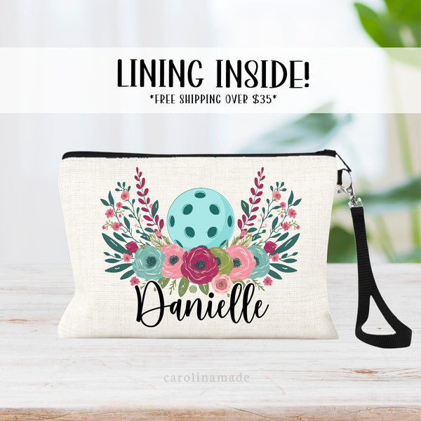 This linen zipper pouch features a beautiful pickleball ball with colorful flowers all around it. The bag is personalized your name under the flowers.