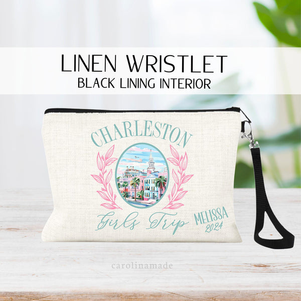 This linen zipper pouch featuring Charleston's Rainbow Row in the center with pink wreaths. Text says Charleston Girls Trip and is personalized with name and year in the bottom corner.