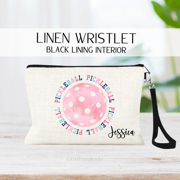 This zipper pouch features a large pink watercolor pickleball with the word pickleball surrounding it. The bag is personalized in the corner with your name.