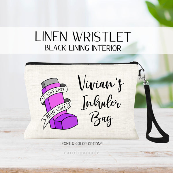 This linen wristlet with black strap & zipper features an asthma inhaler that says: it aint easy bein wheezy. With 5 color options for the inhaler. Purple, Pink, Red, Blue & Teal. Next to it says a personalized name inhaler bag.